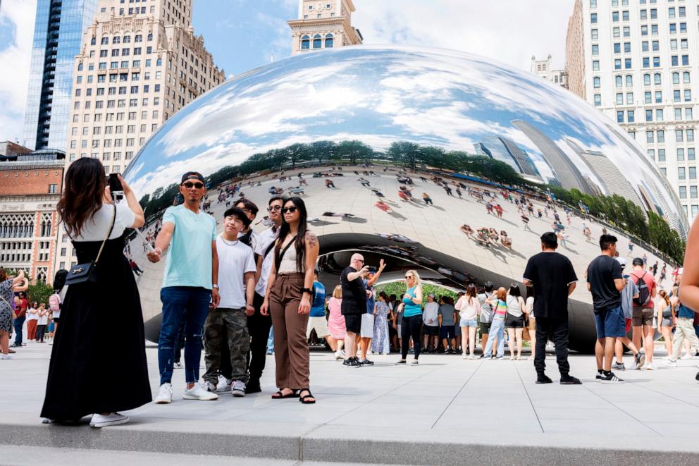 PHOTO: Visitors take photos of the "Cloud Gate" sculpture, also known as the "bean," at Millennium Park, June 23, 2024.