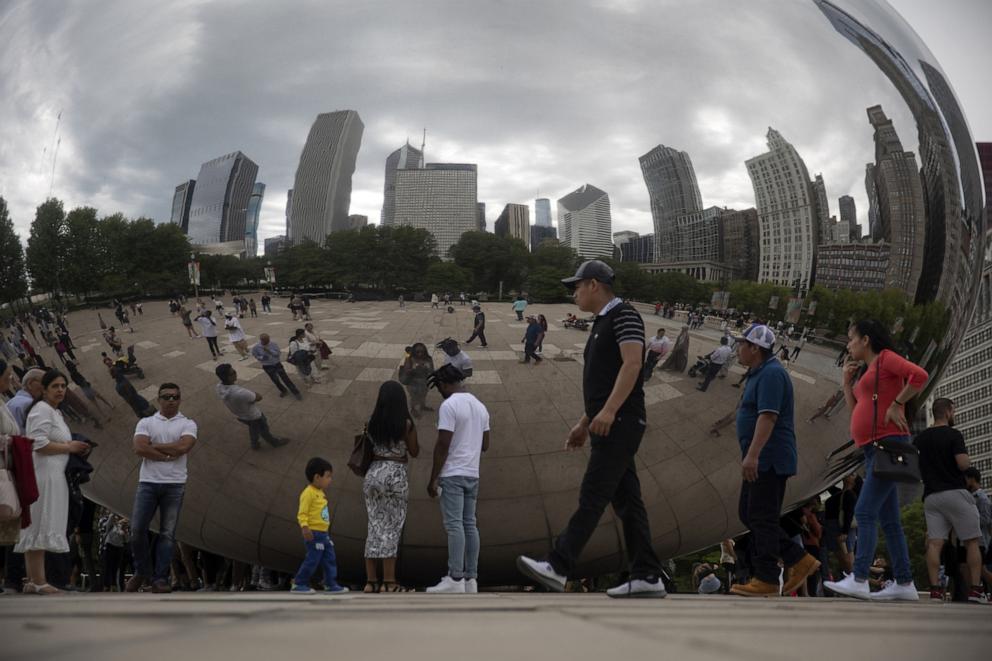 PHOTO: People hang out at the Cloud Gate sculpture, aka the Bean, in Millennium Park on May 15, 2022, in Chicago.