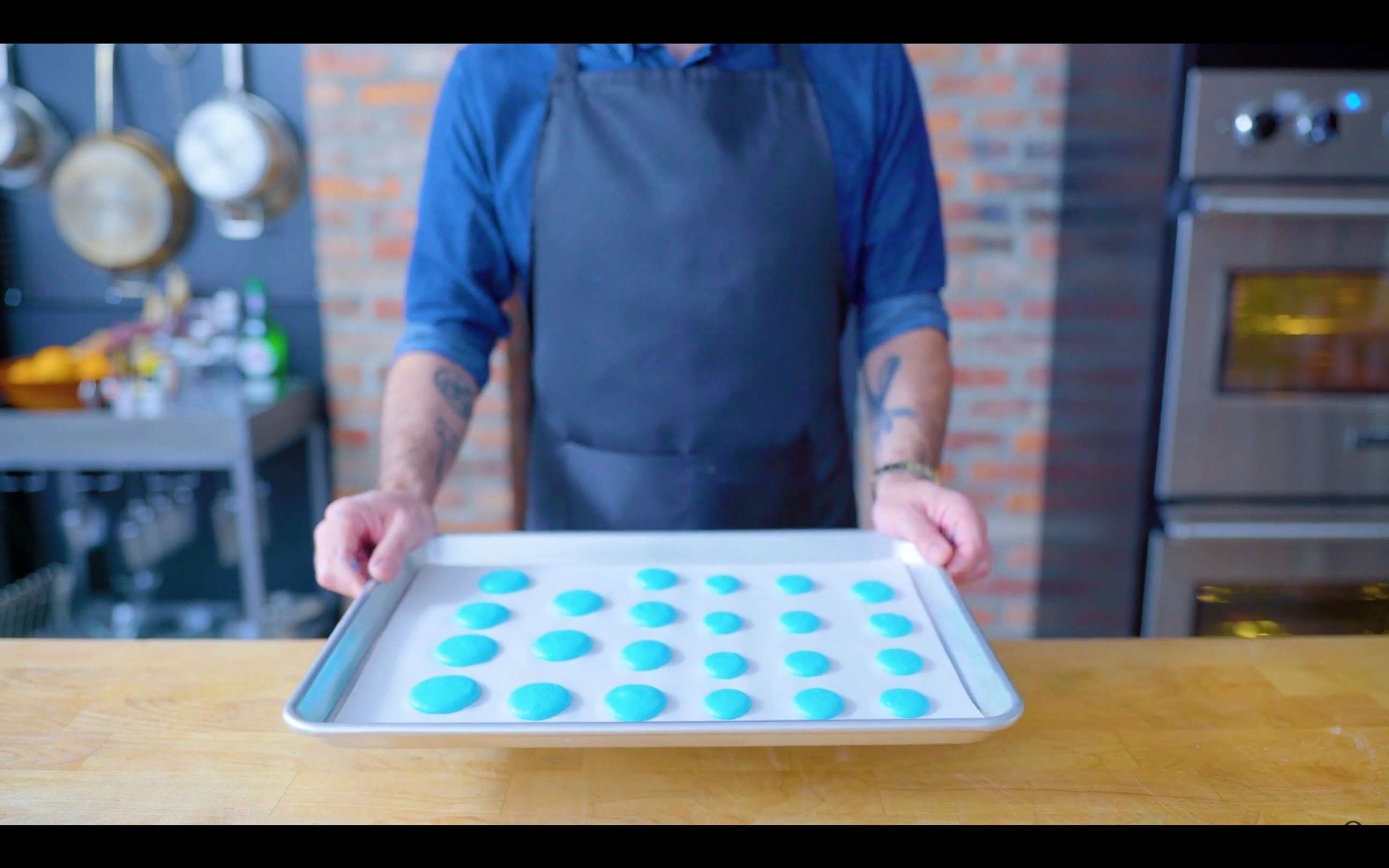 PHOTO: Andrew Rae holds a cookie sheet of blue macarons ready to be baked on "Binging with Babish."