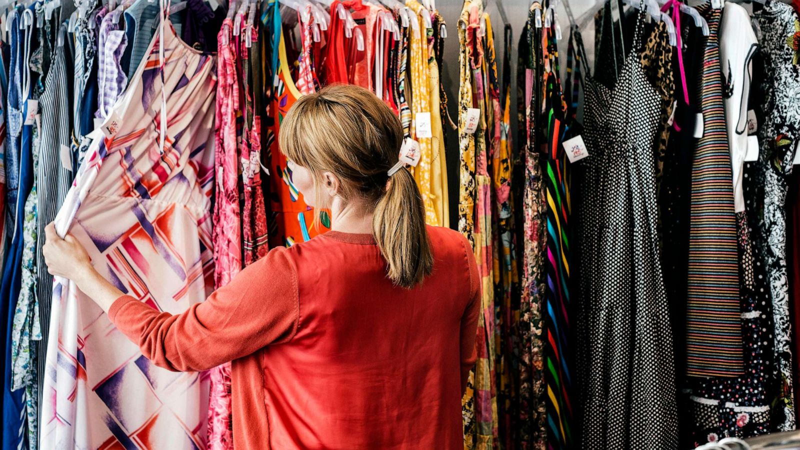 STOCK PHOTO: A woman looks at dresses at a store