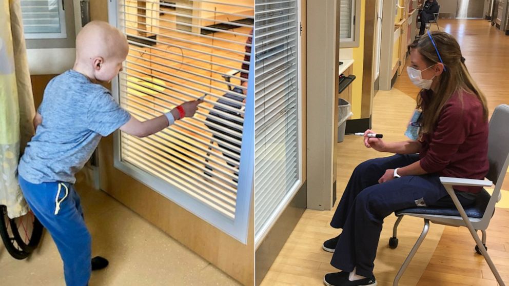 PHOTO: Nurse Allie Schulten plays tic-tac-toe with cancer patient Grant Wolf through a hospital room window, hoping to cheer up the seven-year-old while social distancing.