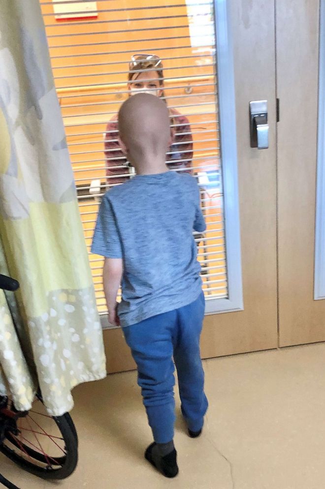 PHOTO: Nurse Allie Schulten plays tic-tac-toe with cancer patient Grant Wolf through a hospital room window, hoping to cheer up the seven-year-old while social distancing.