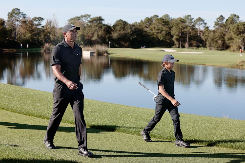 PHOTO: Tiger Woods and Charlie Woods walk the course during the Pro-Am ahead of the PNC golf Championship in Orlando, Fla., Dec. 17, 2021.