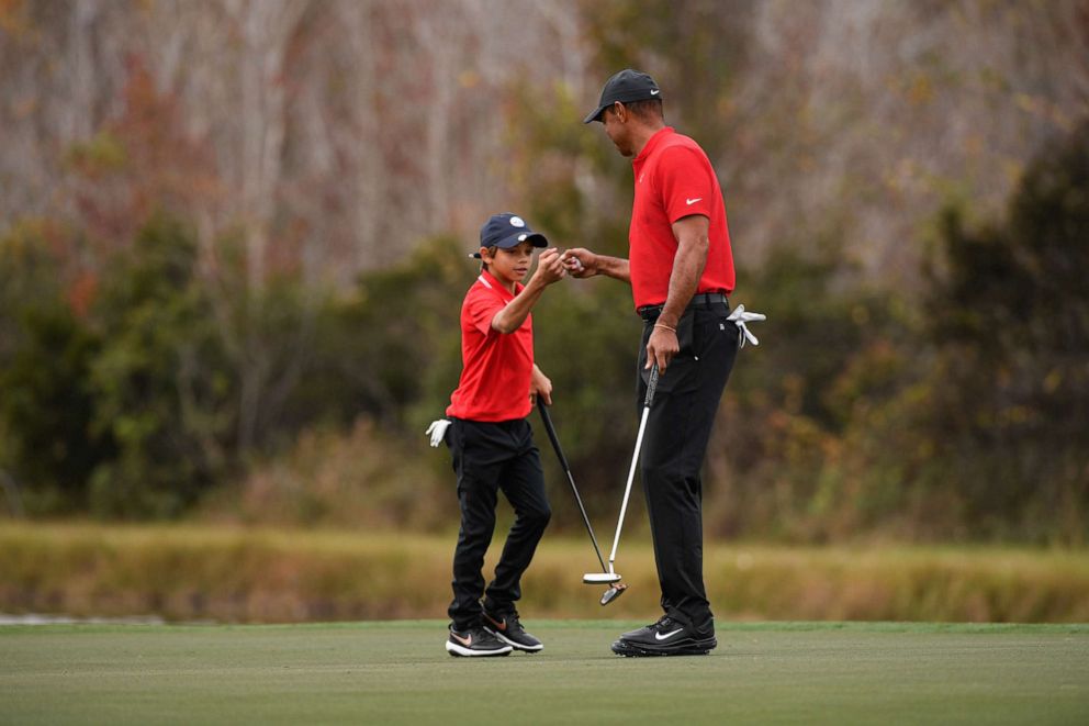 PHOTO: Charlie Woods fist bumps with his father, Tiger Woods, on the 14th green during the final round of the PGA TOUR Champions PNC Championship at Ritz-Carlton Golf Club, Dec. 20, 2020, in Orlando, Florida.