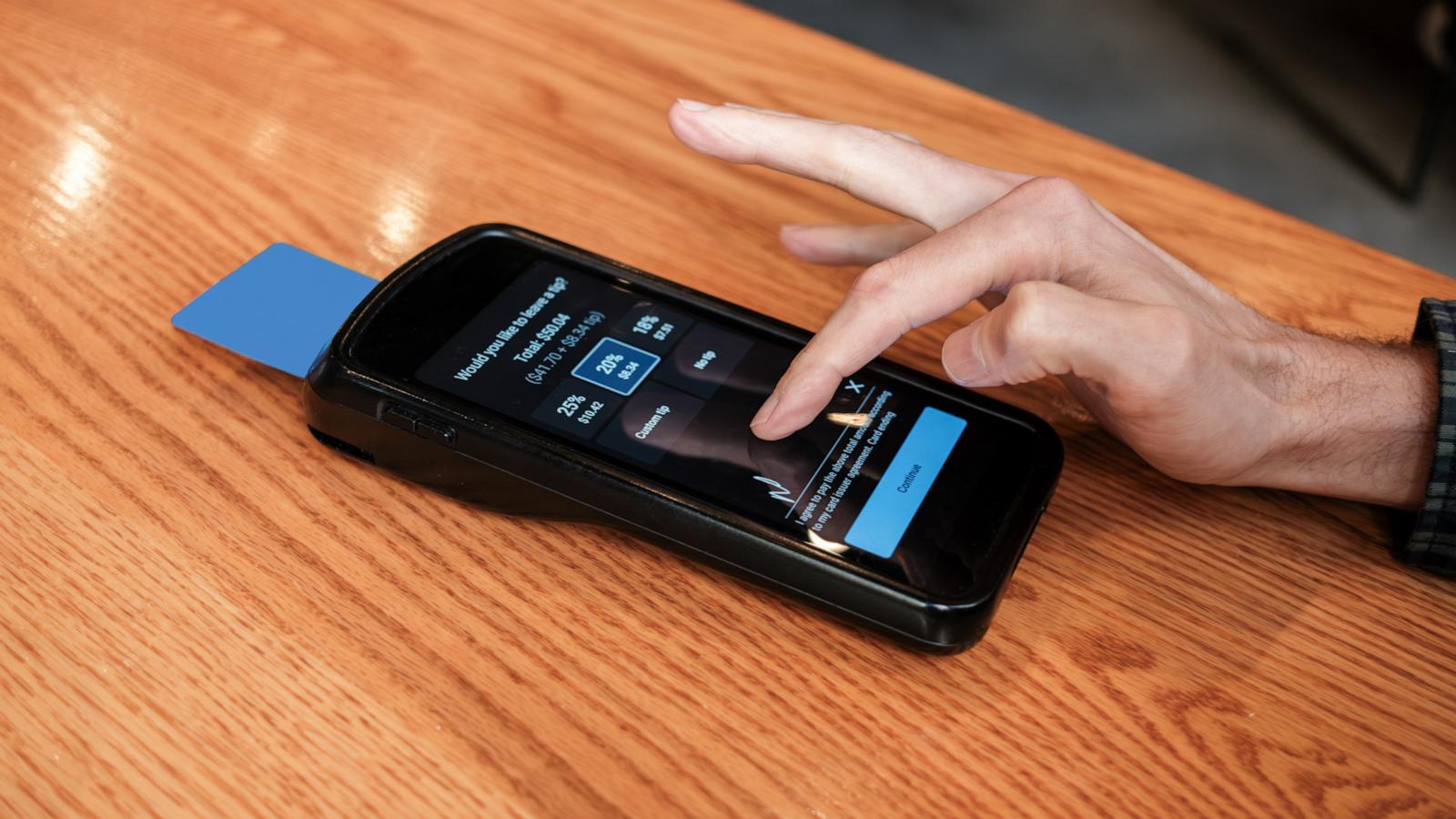 PHOTO: In this undated stock photo, a customer is prompted to select a tip amount on a portable card reader.