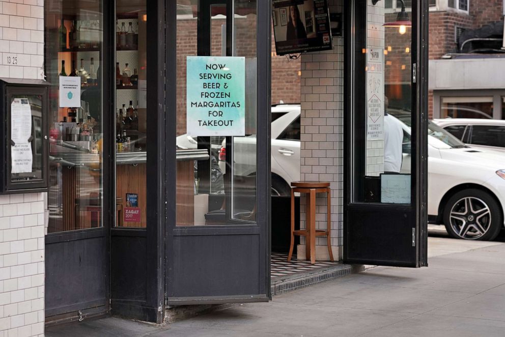 PHOTO: A sign in a restaurant window advertises beer and margaritas for takeout during the coronavirus pandemic, May 19, 2020, in New York.