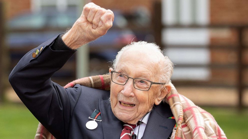 PHOTO: A handout picture released on April 30, 2020 shows Captain Tom Moore waving at a flypast by Battle of Britain Memorial planes to celebrate his 100th birthday in Marston Moretaine.