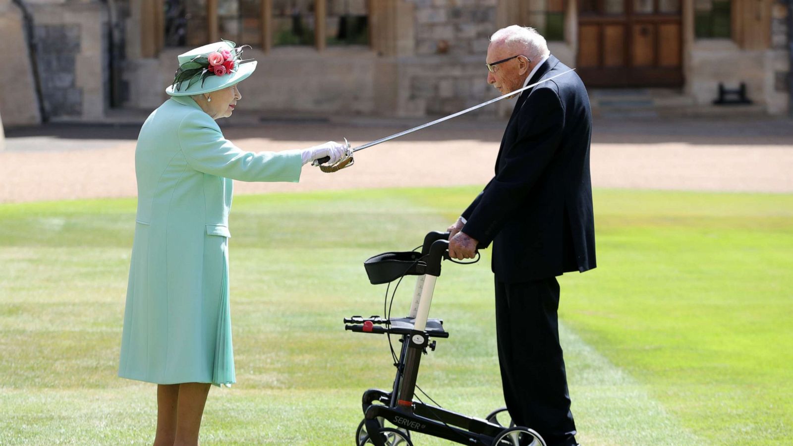 PHOTO: Queen Elizabeth II awards Captain Sir Thomas Moore with the insignia of Knight Bachelor at Windsor Castle, July 17, 2020, in Windsor, England.