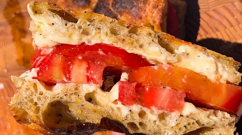 PHOTO: A cross-section of a thick-cut tomato sandwich on fresh focaccia bread.