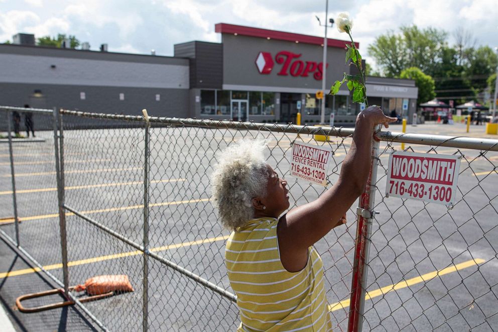 PHOTO: Cariol Horne places a rose on the fence outside the Tops Friendly Market, July 14, 2022, in Buffalo, N.Y. 
