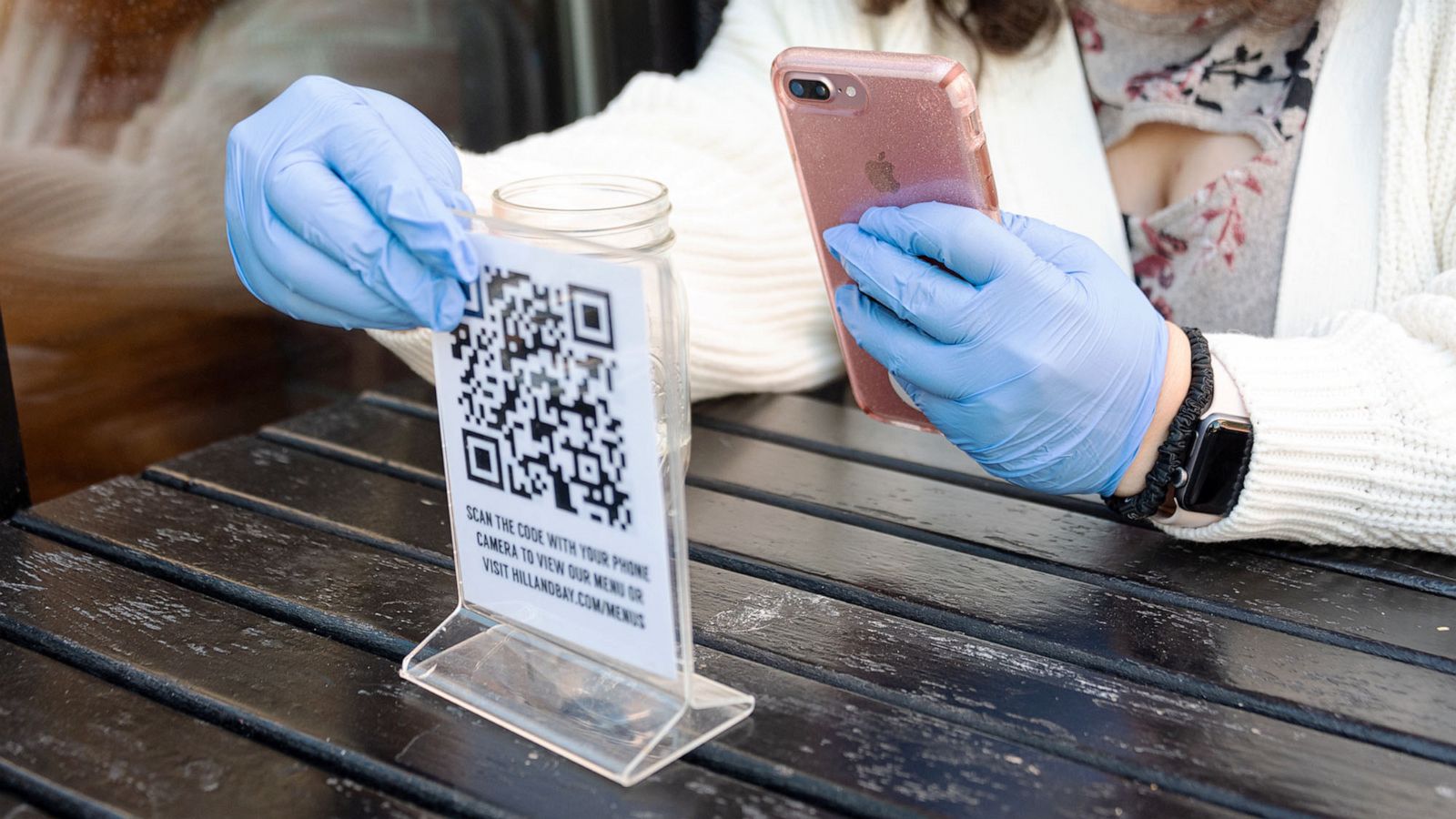 PHOTO: A person wears rubber gloves while scanning a QR code menu at a restaurant in the Kips Bay area of New York, Oct. 14, 2020.