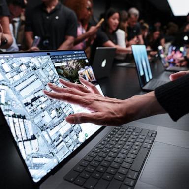 PHOTO: People try out the new MacBook Pro's touch screen following the launch by Apple CEO John Ternus, in Los Angeles, October 28, 2026. 