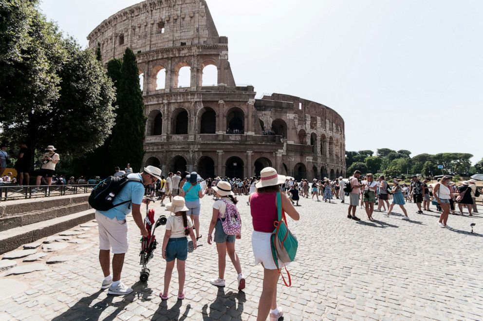 PHOTO: Tourists with umbrellas to protect themselves from the sun at Colosseo area (Colosseum), during the ongoing heat wave with temperatures reaching 40 degrees, on July 19, 2023, in Rome.
