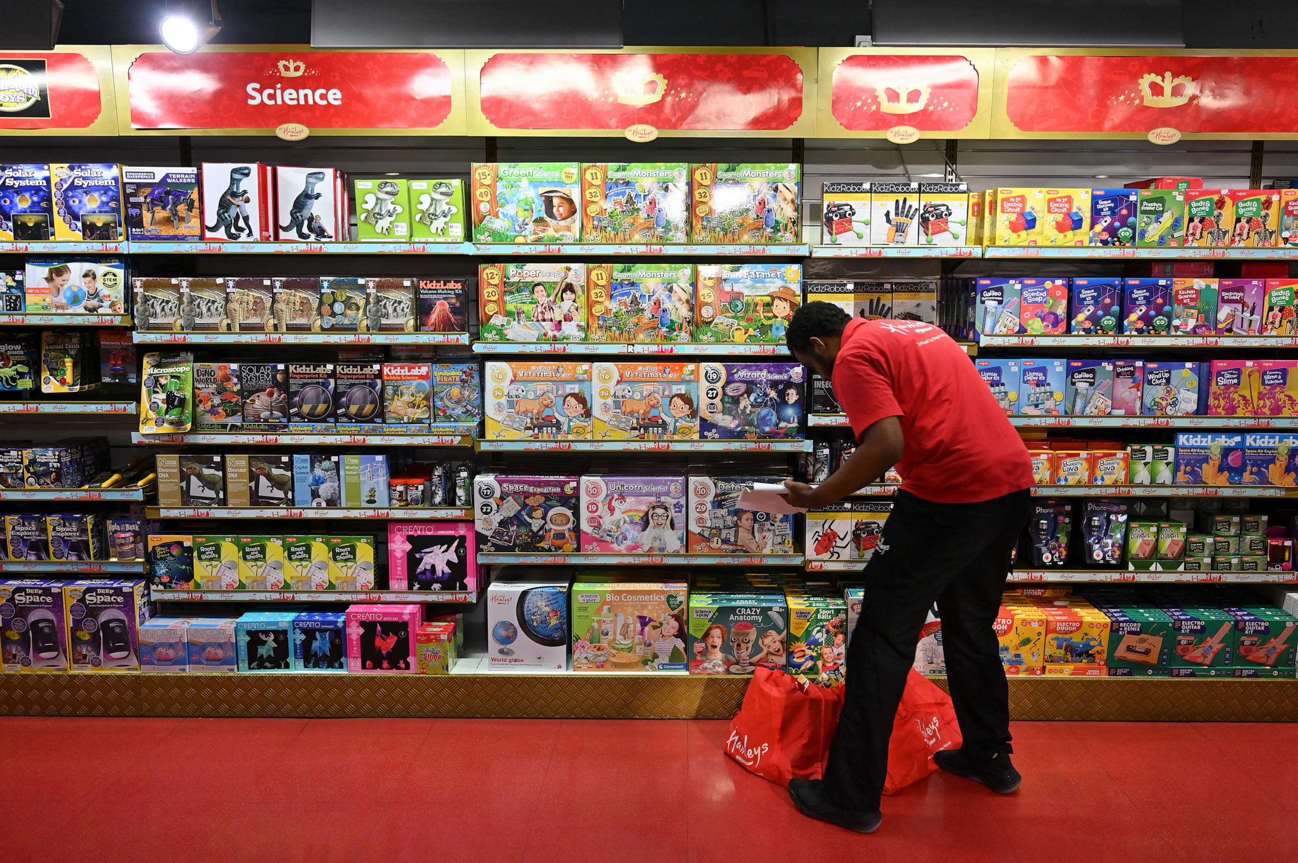 PHOTO: An employee arranges stock on the shelves at Hamley's toy store during a photo call in London, Oct. 14, 2021.