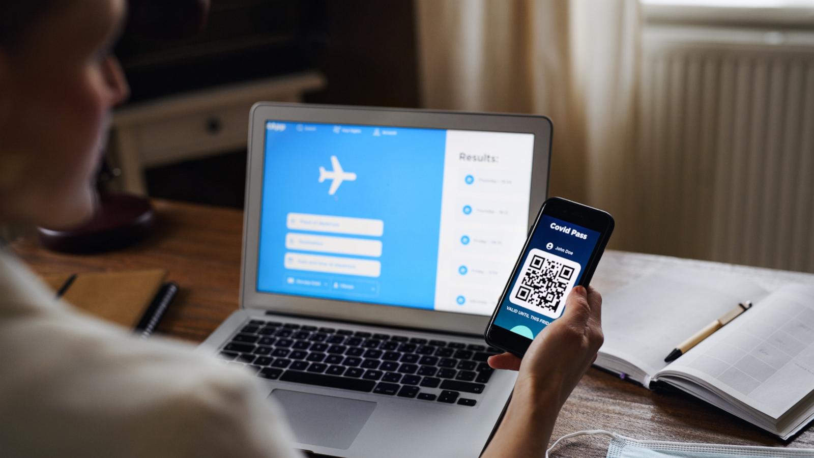 PHOTO: A woman on computer with smartphone app booking travel in an undated stock photo.