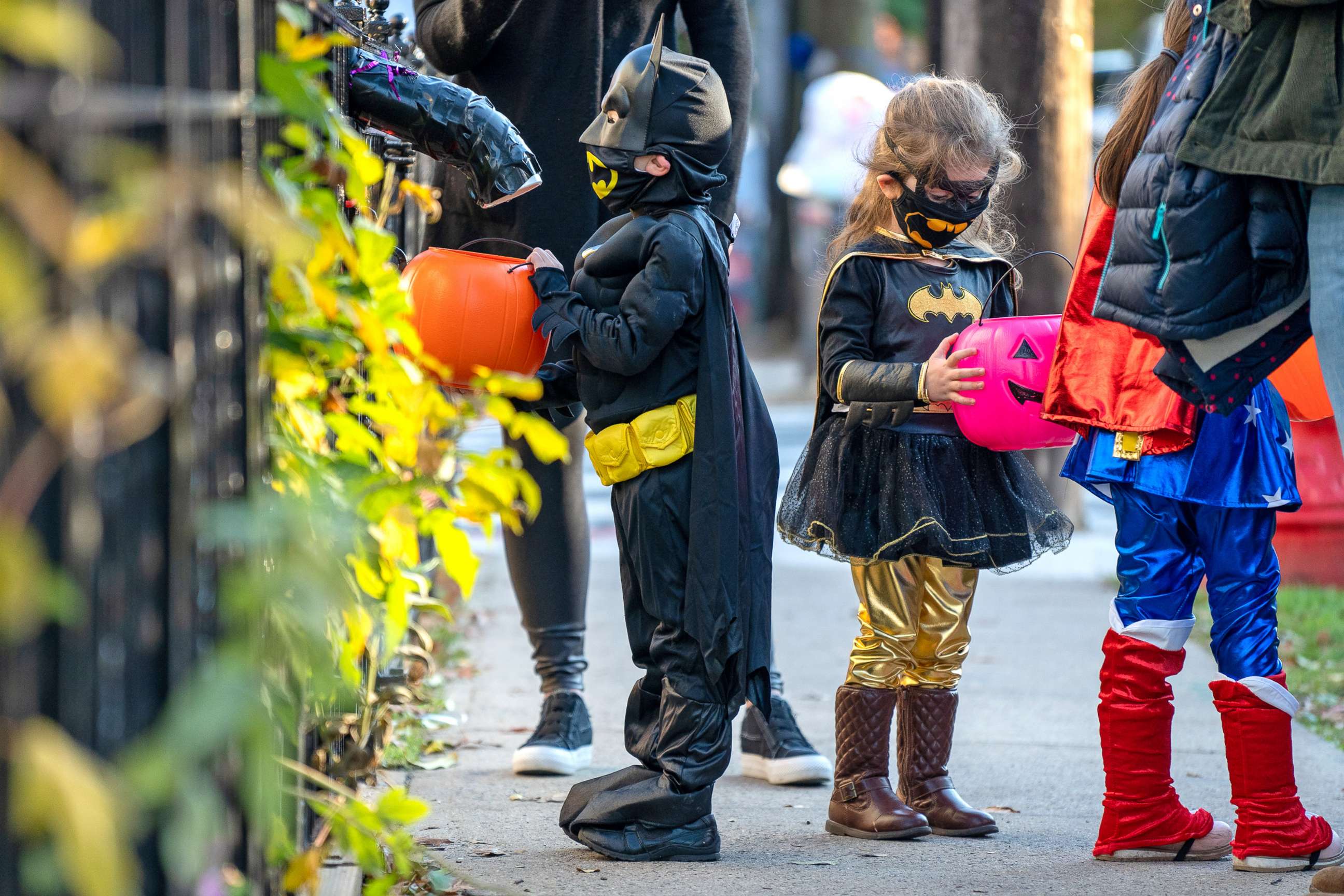 PHOTO: Children receive treats by candy chutes while trick-or-treating for Halloween in Woodlawn Heights on Oct. 31, 2020 in New York City.