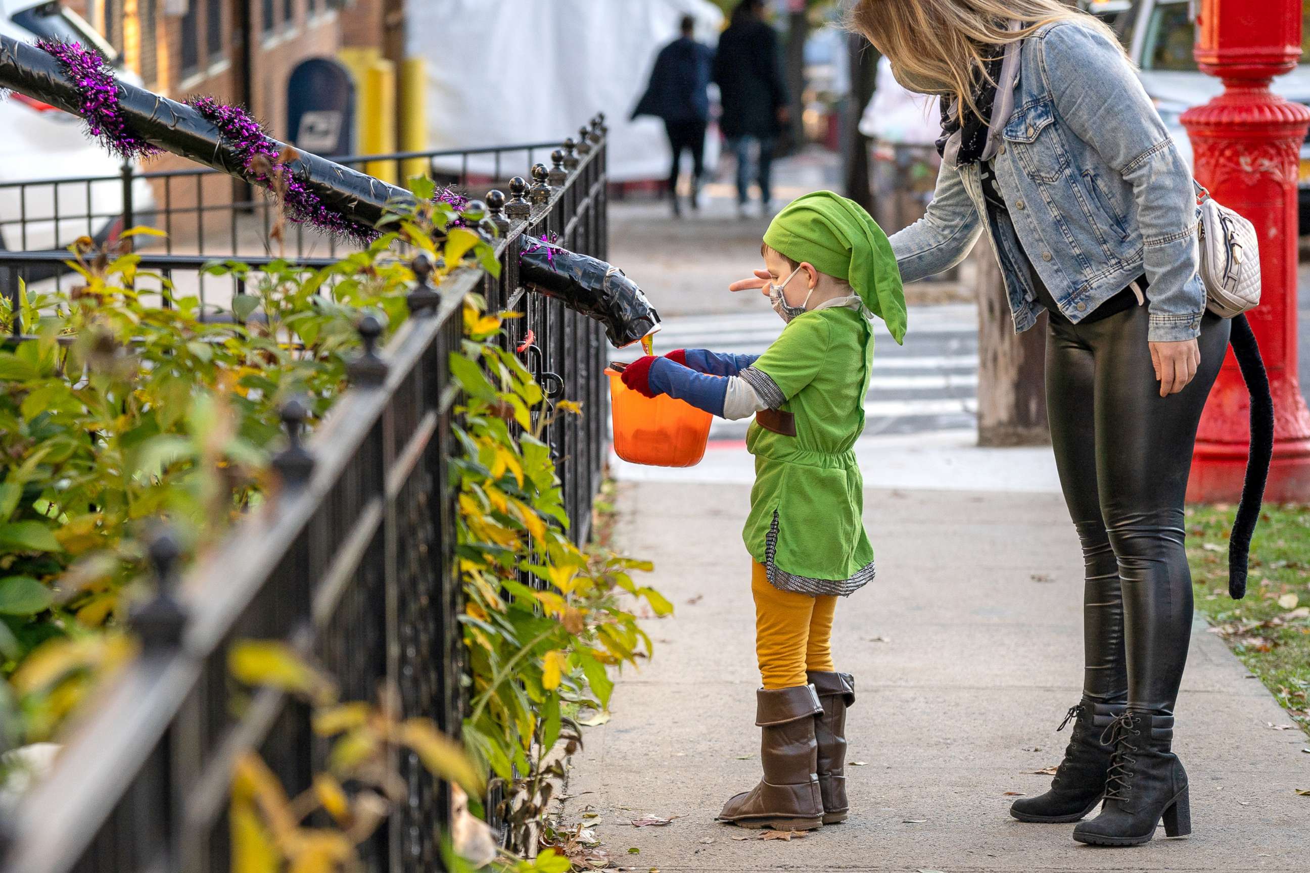 PHOTO: Children receive treats by candy chutes while trick-or-treating for Halloween in Woodlawn Heights on Oct. 31, 2020 in New York City.