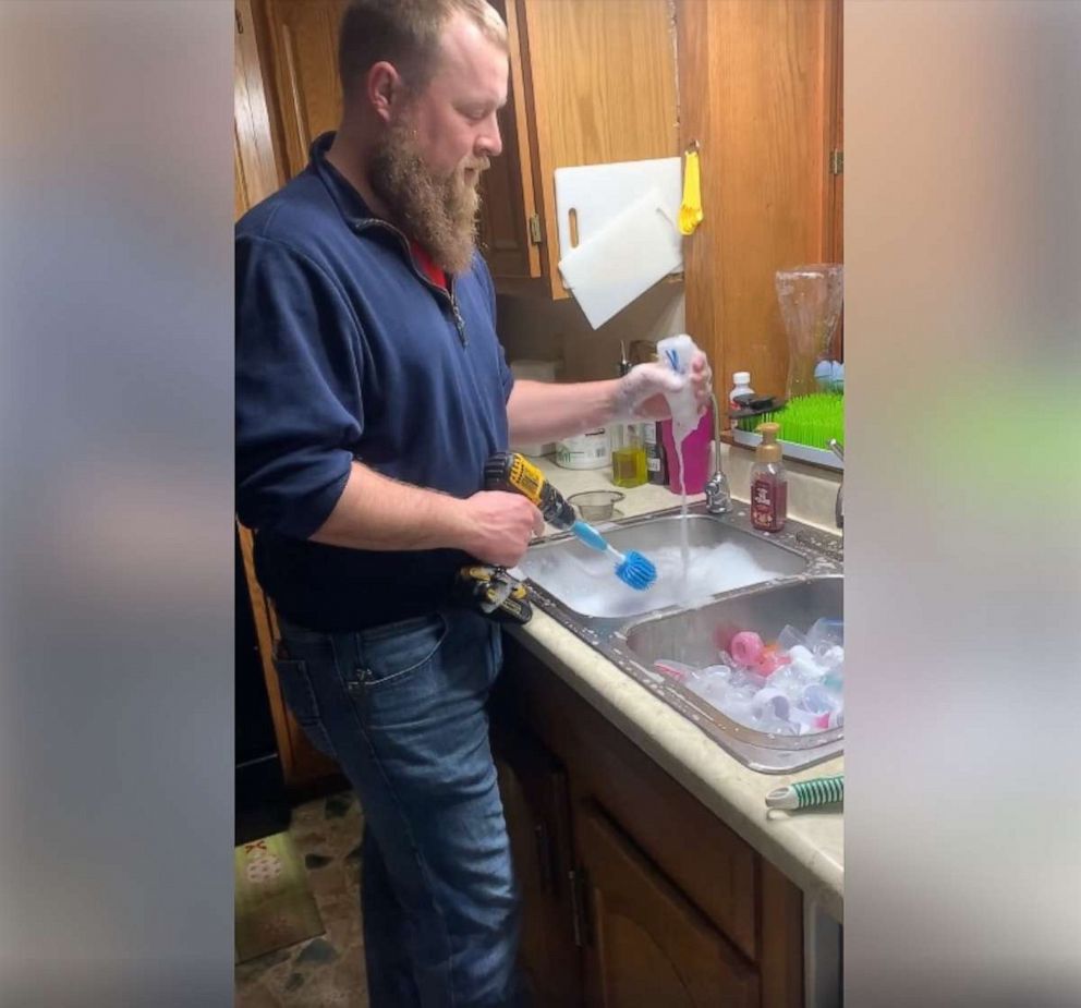 PHOTO: Aerol Peterson, proud dad to Natashia, Arya and Trae, 7 months, from Lincoln, Nebraska, was recorded by his wife Christy as he washed the bottled using a power drill.
