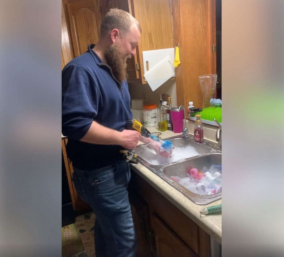 PHOTO: Aerol Peterson, proud dad to Natashia, Arya and Trae, 7 months, from Lincoln, Nebraska, was recorded by his wife Christy as he washed the bottled using a power drill.