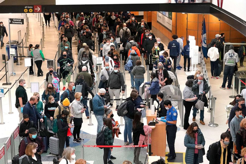 PHOTO: Travelers wear masks as they wait in a line for a TSA security check, on Dec. 10, 2021, at Seattle-Tacoma International Airport in Seattle.