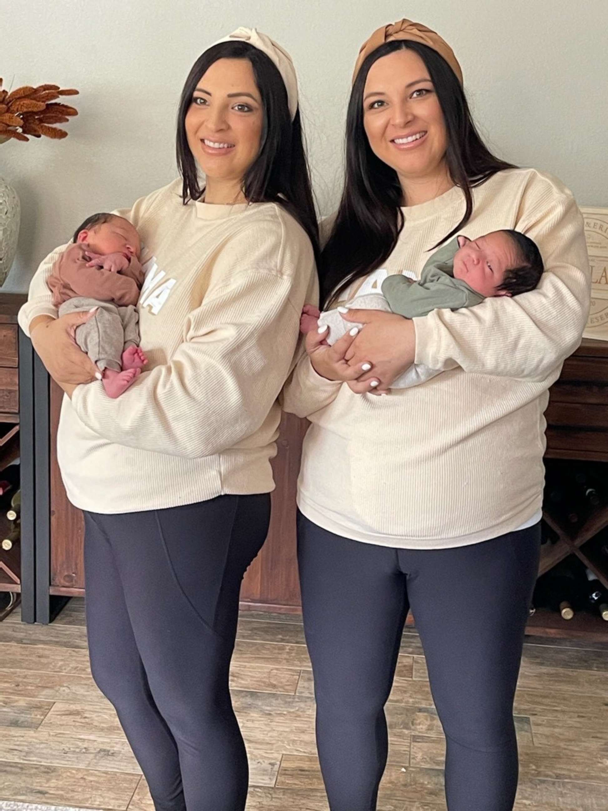 PHOTO: Erin Cheplak, left, holding her son, Silas, poses next to her twin sister, Jill Justiniani, holding her son, Oliver.
