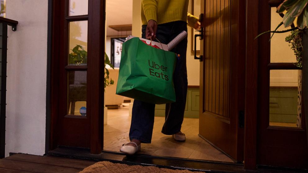 PHOTO: A customer holds a delivery from Uber Eats with retail items.