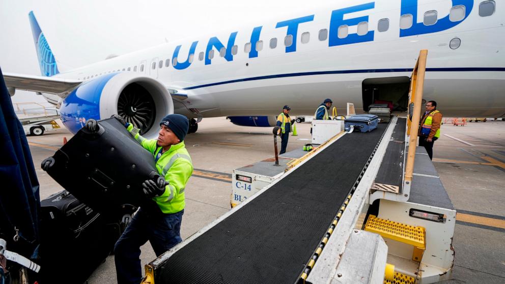 PHOTO: In this Dec. 21, 2023 file photo, Juan Chavez handles baggage as is comes off an aircraft upon landing at George Bush Intercontinental Airport in Houston. 