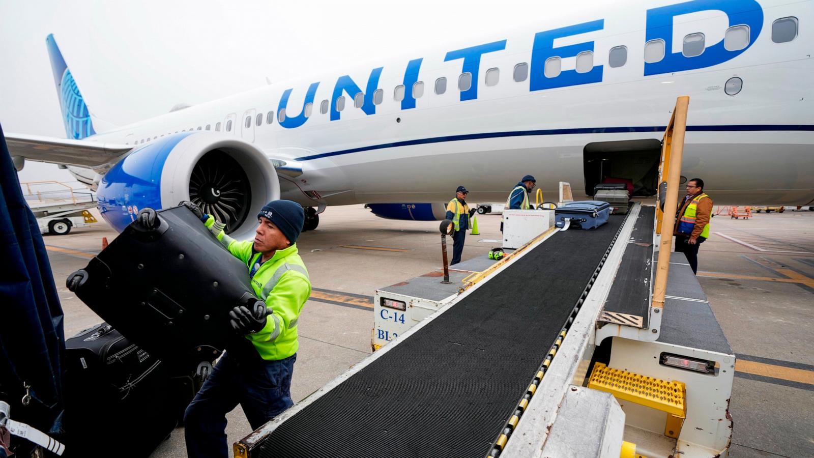 PHOTO: In this Dec. 21, 2023 file photo, Juan Chavez handles baggage as is comes off an aircraft upon landing at George Bush Intercontinental Airport in Houston.