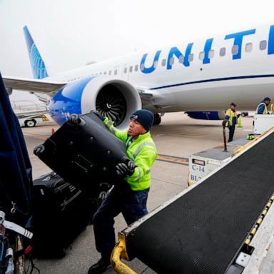 PHOTO: In this Dec. 21, 2023 file photo, Juan Chavez handles baggage as is comes off an aircraft upon landing at George Bush Intercontinental Airport in Houston. 