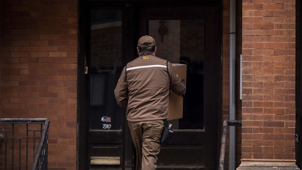 PHOTO: A UPS driver carries a package in the Lincoln Park neighborhood of Chicago, Nov. 30, 2020.