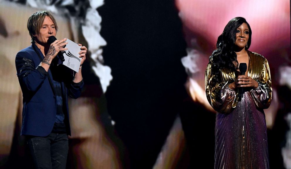 PHOTO: Co-hosts Keith Urban, left, and Mickey Guyton speak onstage at the 56th Academy of Country Music Awards at the Grand Ole Opry on April 18, 2021, in Nashville, Tenn.