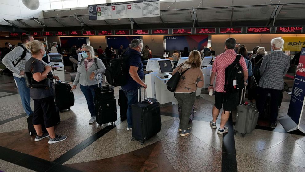 Travellers wait to approach the ticketing counter for Delta Airlines in Denver International Airport, Sept. 14, 2021, in Denver.