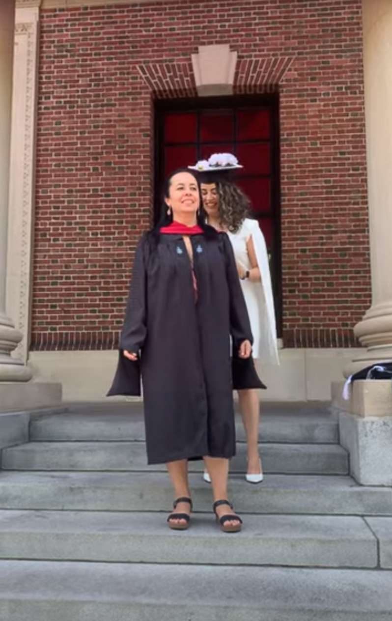 PHOTO: Nataly Morales Villa puts her cap and gown on her mother at her graduation from the Harvard Graduate School of Education on May 25, 2022.