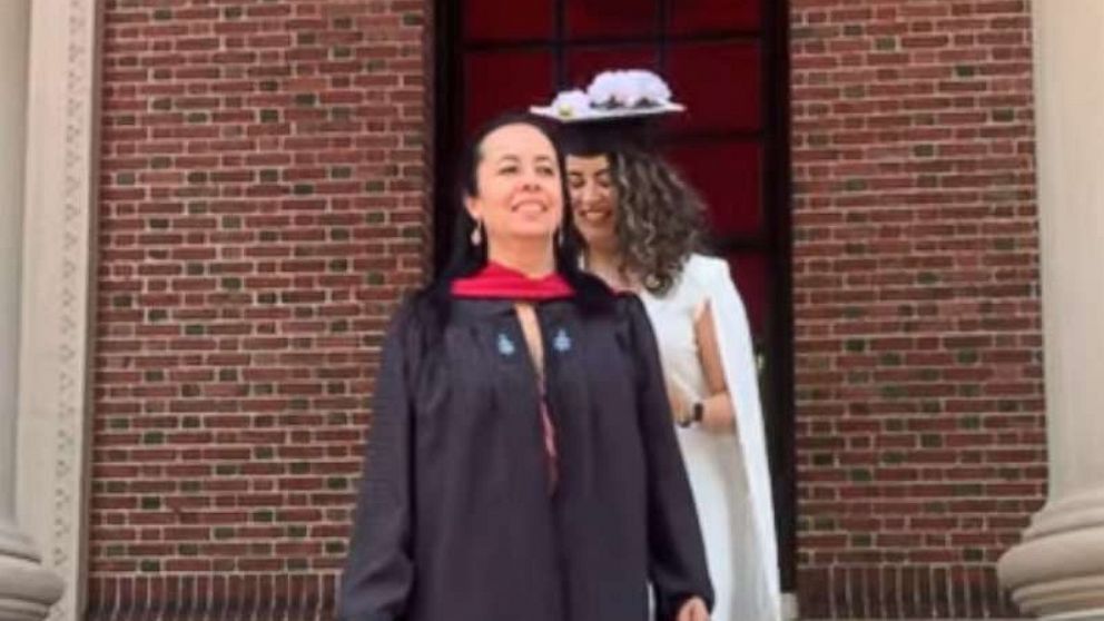 PHOTO: Nataly Morales Villa puts her cap and gown on her mother at her graduation from the Harvard Graduate School of Education on May 25, 2022.