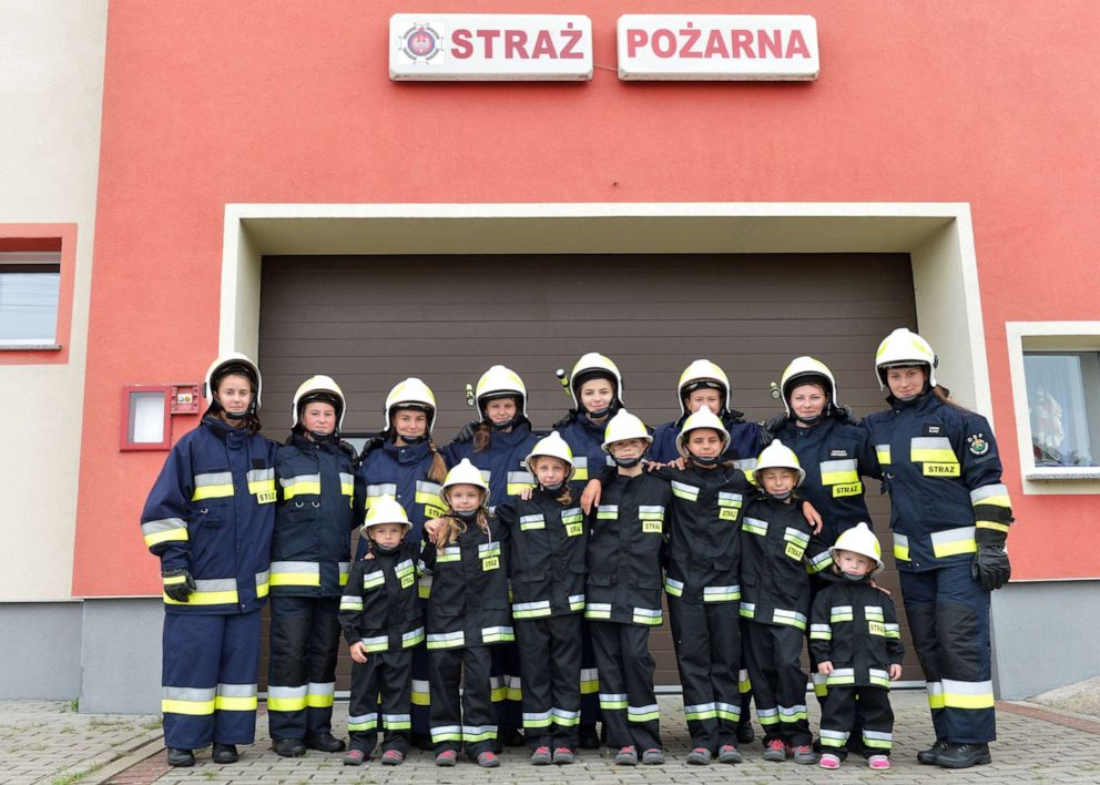 PHOTO: Girls pose with the volunteer fire department in the town of Miejsce Odrzanskie, Poland, July 31, 2019.