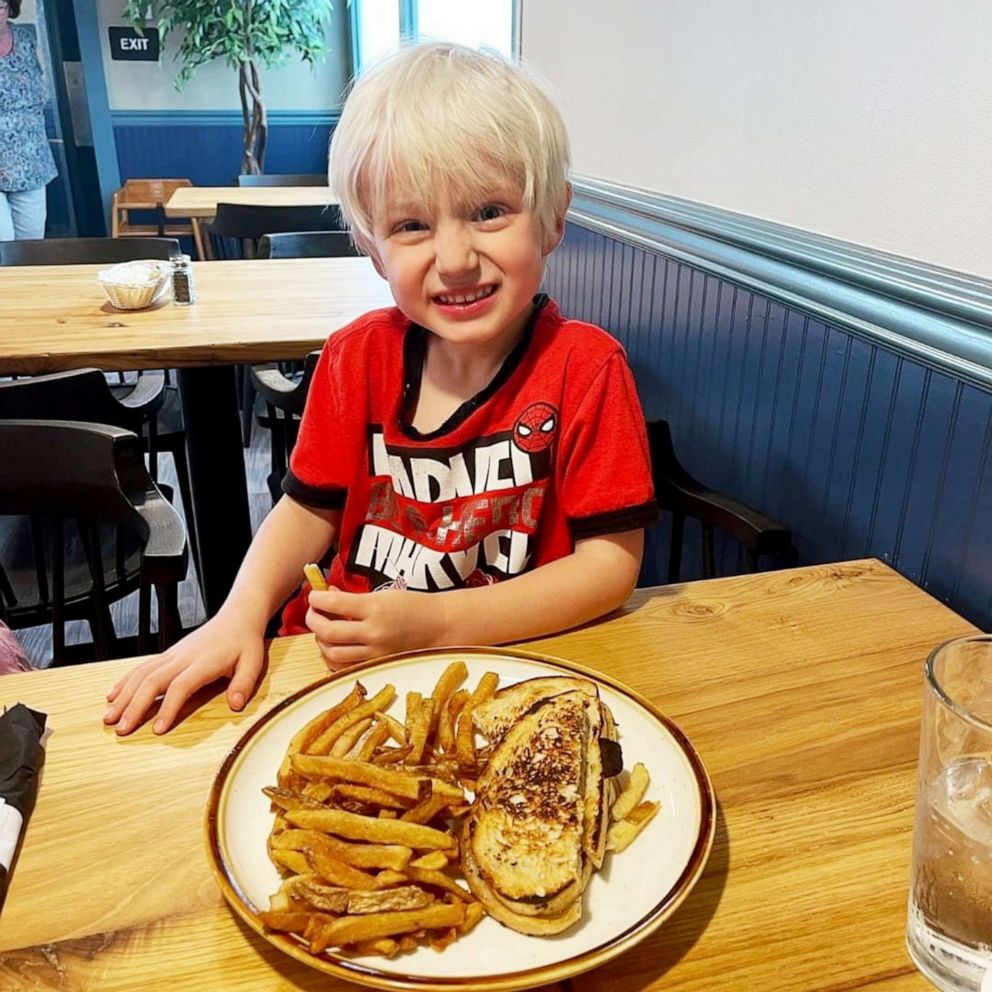 PHOTO: Adam Perry's son smiling next to a plate of food.