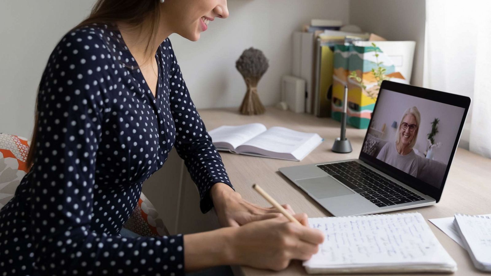 PHOTO: A woman takes notes during a virtual interview in this stock photo.