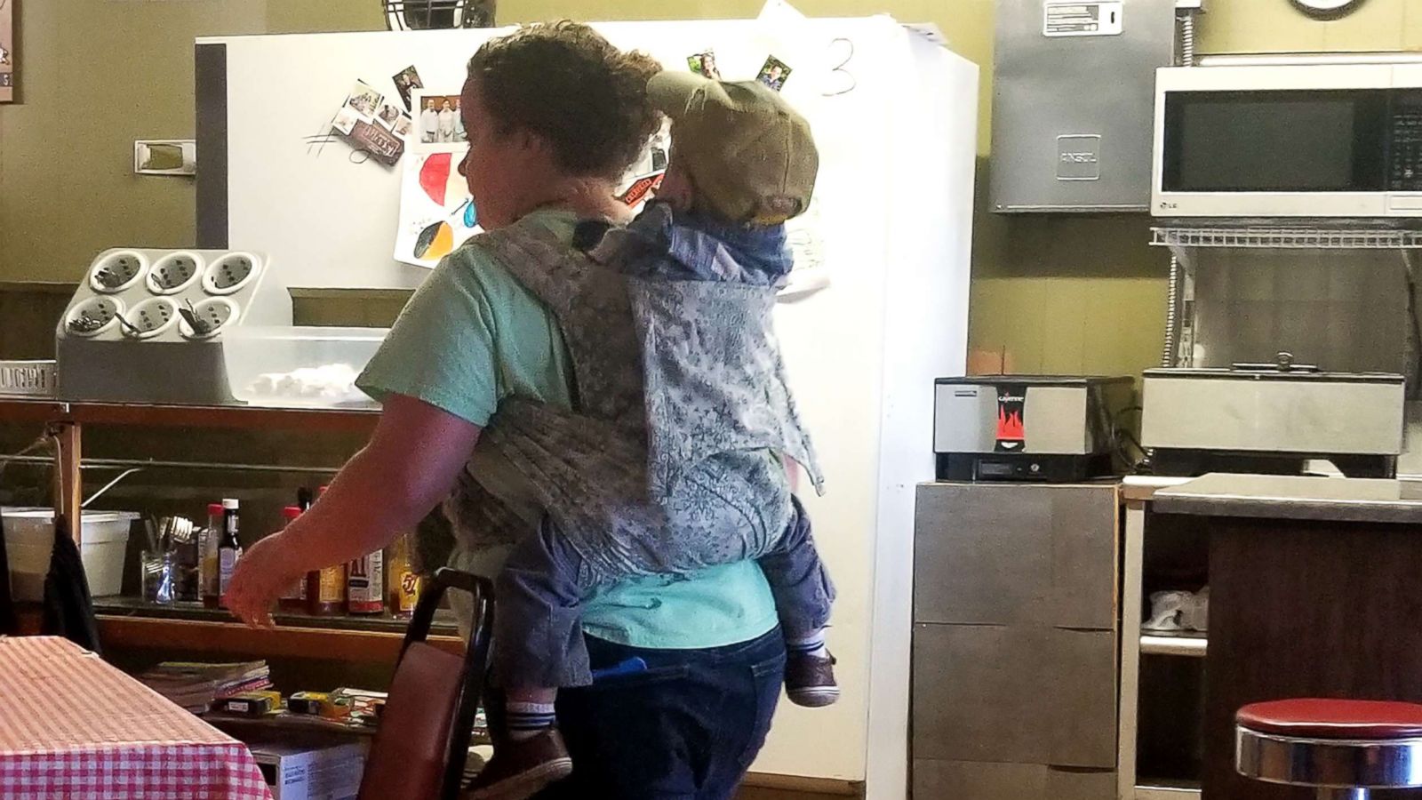 PHOTO: Kori Dotson is seen carrying her toddler on her back during her waitressing shift.