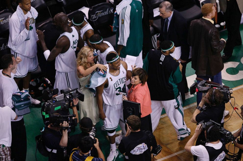 PHOTO: Heather Walker, a vice-president of public relations for the Boston Celtics, escorts Paul Pierce out onto the court.