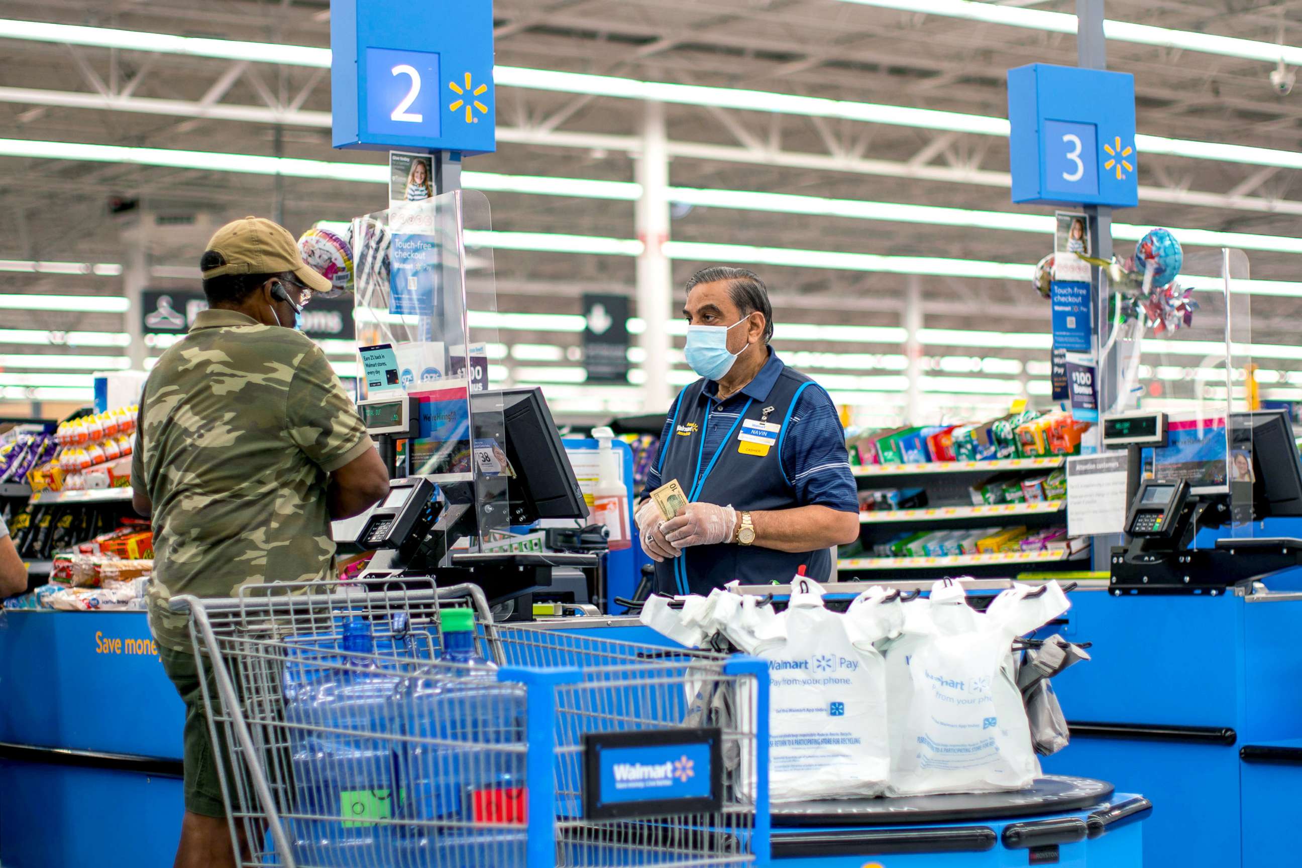PHOTO: A cashier and a shopper are pictured wearing masks at a Walmart store in North Brunswick, New Jersey, July 20, 2020. 