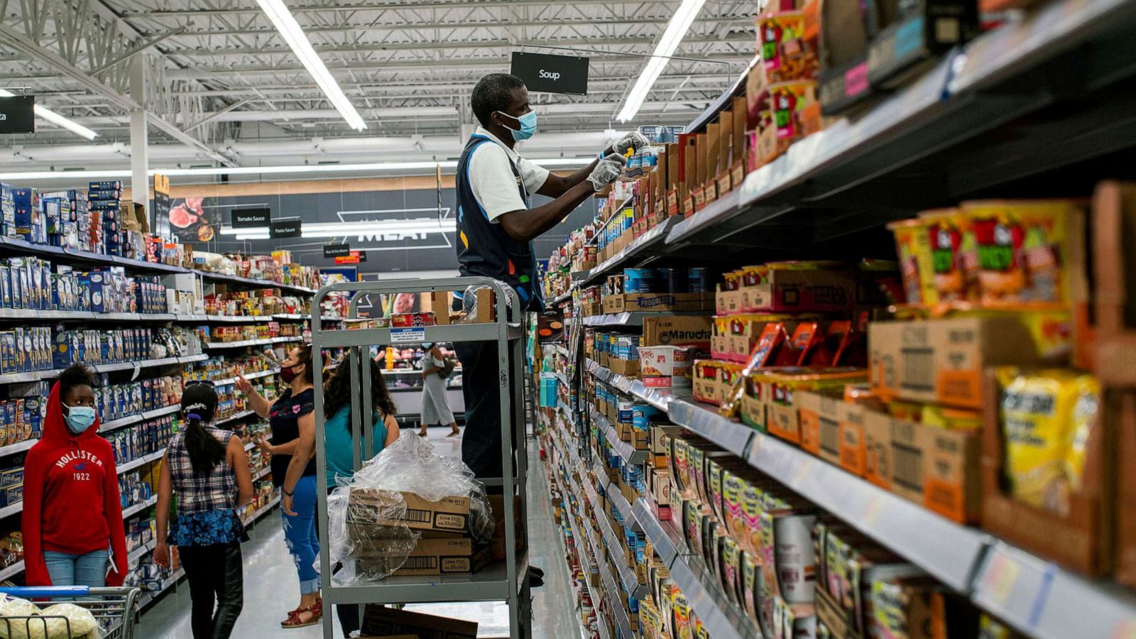 PHOTO: A worker restocks shelves in the grocery aisle at a Walmart store, in North Brunswick, N.J., July 20, 2020.