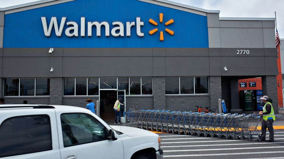 PHOTO: Workers move shopping carts outside a Walmart store in Lakewood, Calif., May 15, 2022.