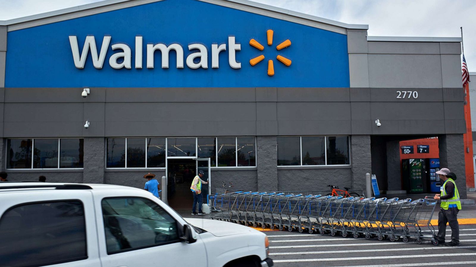 PHOTO: Workers move shopping carts outside a Walmart store in Lakewood, Calif., May 15, 2022.