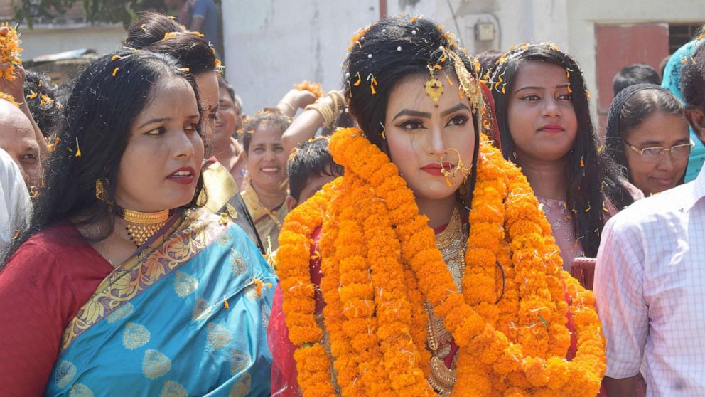 PHOTO:Relatives of groom Tariqul Islam welcome bride Khadiza Akter Khushi with a floral wreath as she arrives to groom's house during their wedding in Meherpur, Sept. 21, 2019.