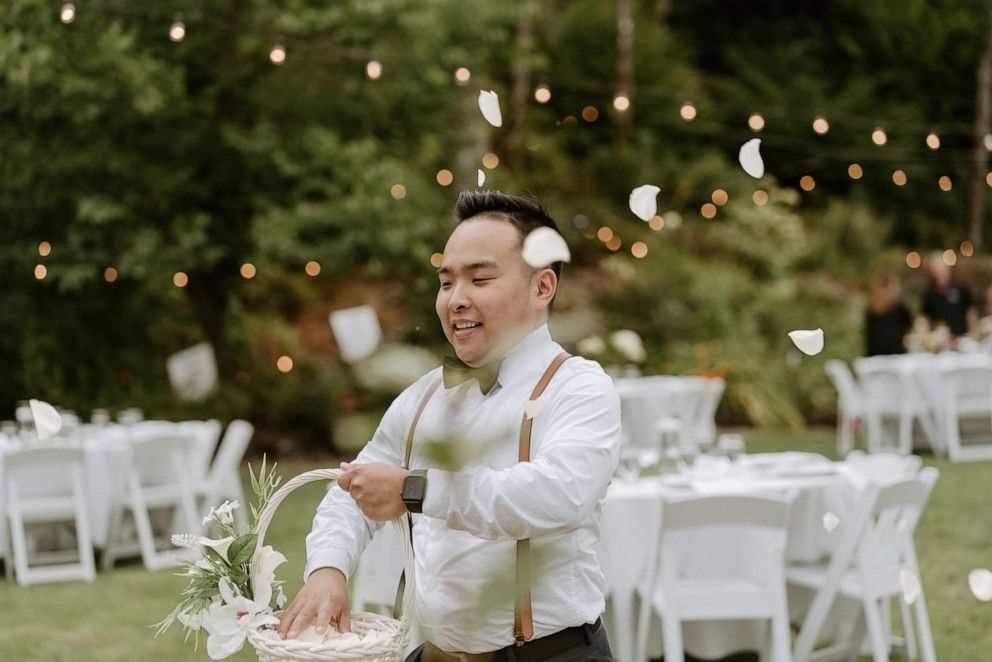 PHOTO: Close up of Lily Tran's "flower man" sprinkling flower petals along the aisle on her wedding day.