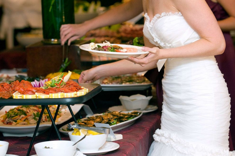 PHOTO: A bride picks from a buffet in this stock photo.