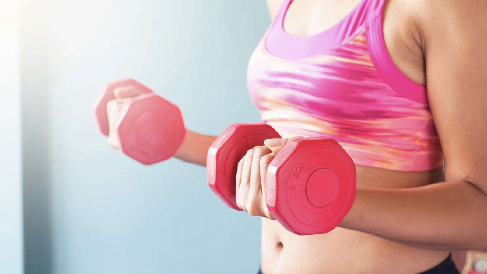 PHOTO: Woman holding red dumbbells. Workout