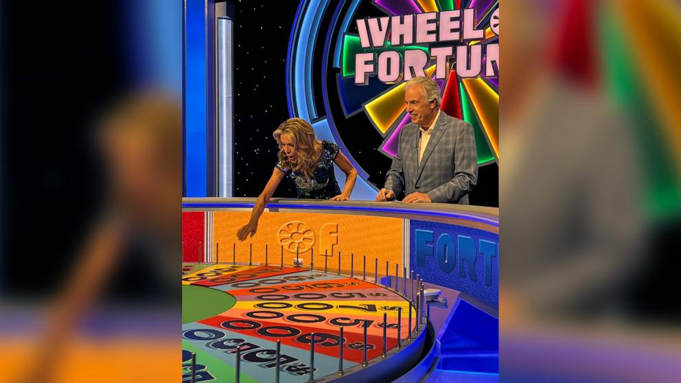 PHOTO: Vanna White spins the wheel alongside Chris Connelly on the “Wheel of Fortune” set.