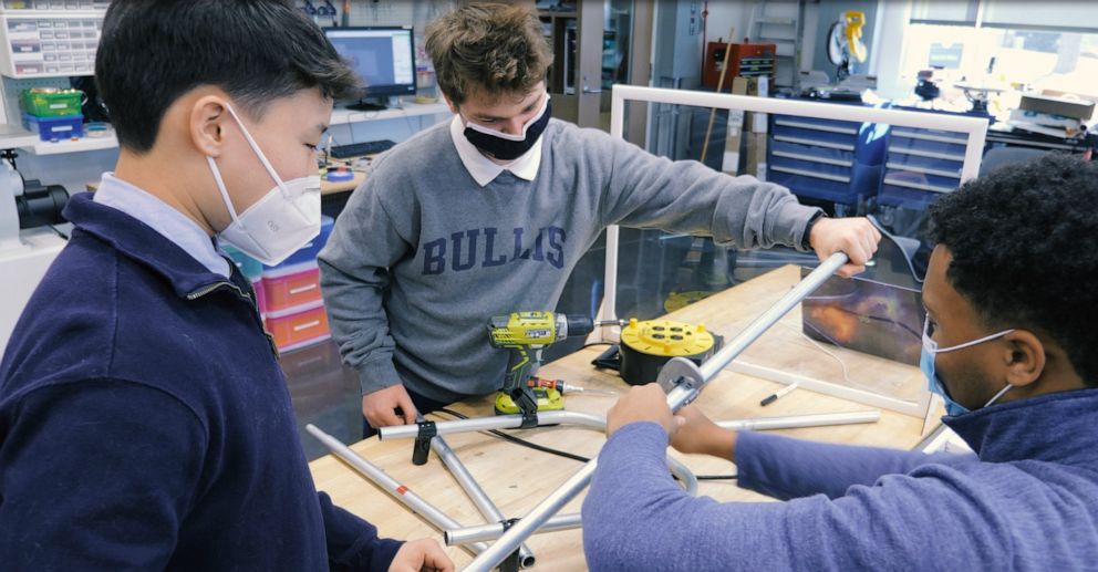 PHOTO: Bullis School students Evan Beach, Benjamin Gordon and Jewel Walker work on the wheelchair-stroller attachments for Jeremy King.