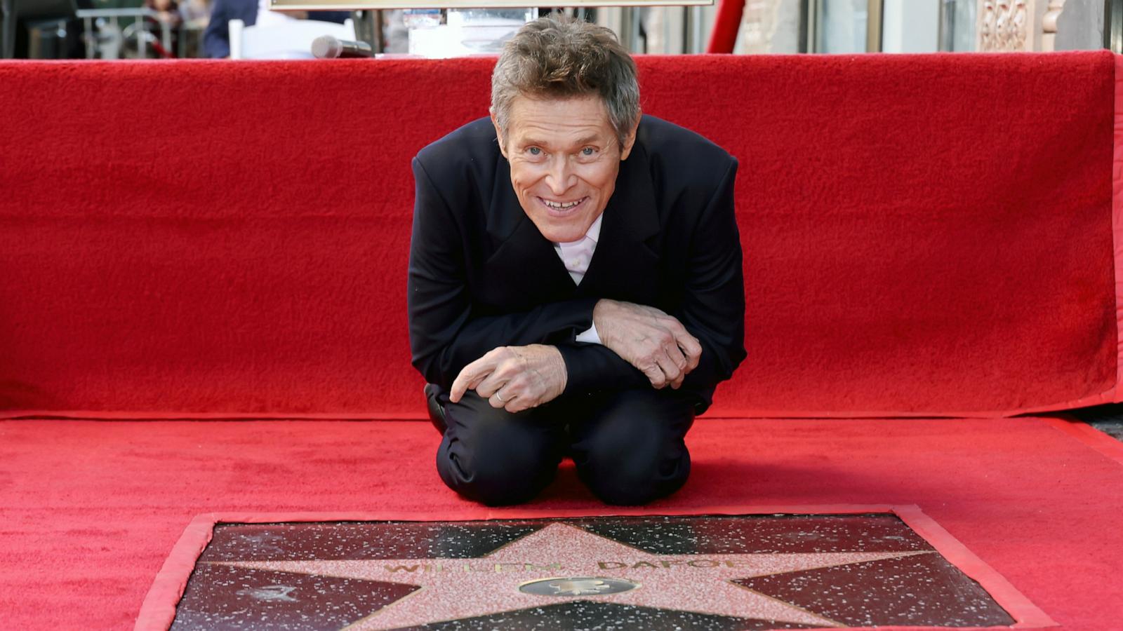 PHOTO: Willem Dafoe poses with his star during his Hollywood Walk of Fame Star Ceremony on January 08, 2024 in Hollywood, California.